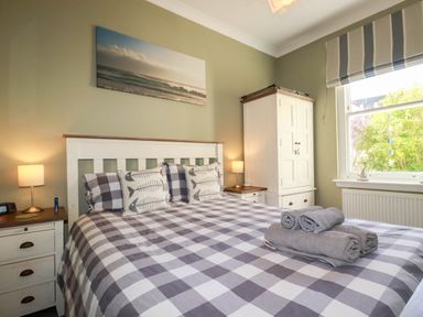 A bedroom with a bed and wardrobe at Seashore House in Porth
