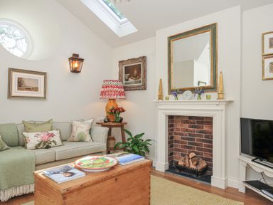 A living room with a sofa and decorative items at The Coach House at Pendower House Fowey