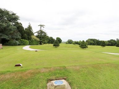 A golf course with trees and a paved path at Lodge 8 in Louth