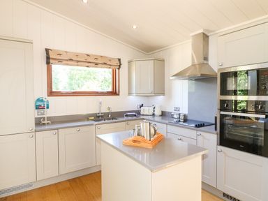 A kitchen with grey countertops a central island stainless steel oven and microwave at Brooke in Exton Rutland
