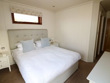 A bedroom with a double bed with pillows bedside tables and a window at Burley in Exton Rutland
