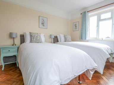 A bedroom with two single beds bedside tables lamps and a window at Bower View in Madley