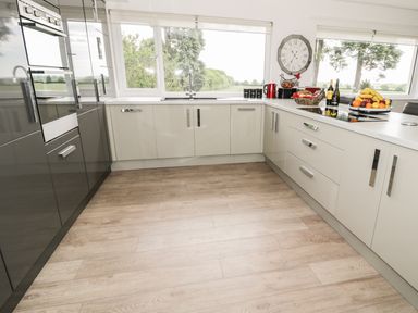A kitchen with cabinets ovens a sink a stove and a countertop with fruit and kitchen items at Manor House in Warkworth