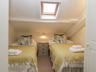 A bedroom with two single beds with yellow blankets and a skylight window at Crannacombe Farmhouse in Loddiswell