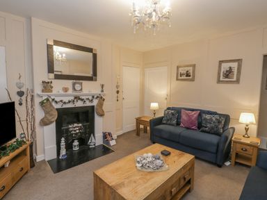 A living room with a fireplace sofa coffee table and wall art at Robins Nest in Whitby