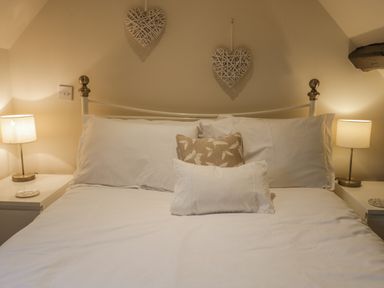 A bed with white pillows and two bedside tables with lamps in a bedroom at Robins Nest in Whitby
