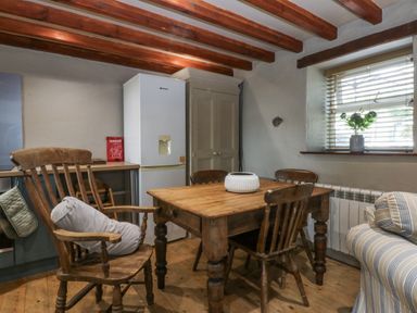 A dining room with a table and chairs at Cegin Foch in Chwilog