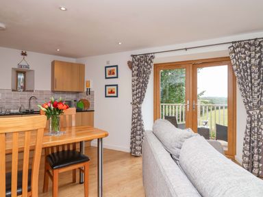 A living room with a dining area and kitchen at Cawsand Tideford