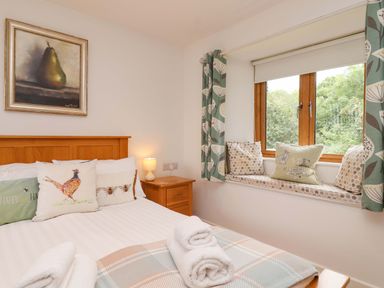 A bedroom with a bed and window seat at Cawsand in Tideford