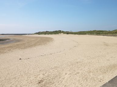 A sandy beach with dunes and clear sky at 5 Chandlers Yard in Burry Port