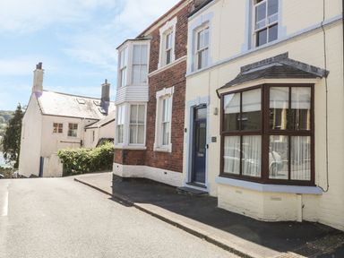 A street view of brick and painted houses with windows and a door at Chwech in Menai Bridge