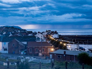 A coastal town with buildings near a harbor with water and cloudy sky at Harbour View Cottage in Watchet