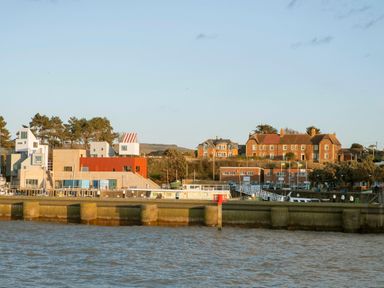 A waterfront scene with various buildings including modern and traditional styles by the water at Harbour View Cottage in Watchet