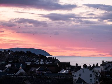 A coastal town with houses and hills during a sunset at Harbour View Cottage Watchet