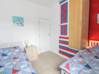 A bedroom with two single beds and a nightstand between them at Swanage Bay Apartment in Swanage