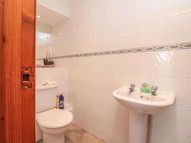 A bathroom with a toilet and a pedestal sink at Sorrel Cottage in Padstow