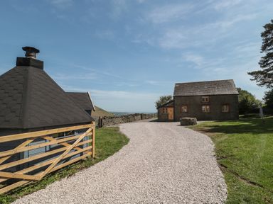 An outdoor view of a gravel pathway and a building at Penrhiwarwydd Barn in Pontywaun