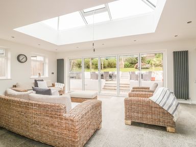 A sitting room with wicker sofas and a skylight at The Orchard in Crantock
