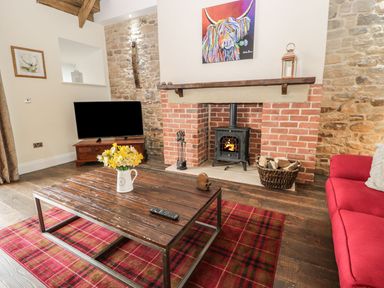 A living room with a fireplace and sofa at The Turnip Barn