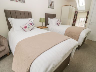 A bedroom with two beds and a table at The Turnip Barn in 