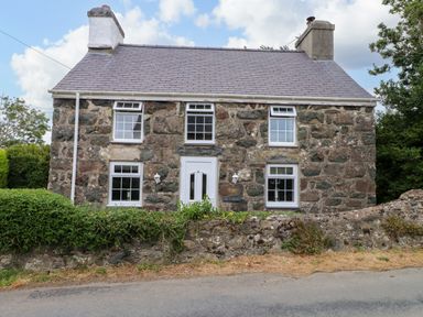 A house with stone walls and windows at Tan Y Goeden in Morfa Nefyn