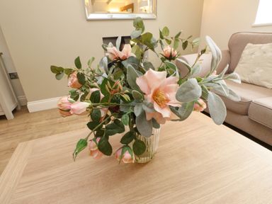A flower arrangement in a vase on a table at Tan Y Goeden in Morfa Nefyn