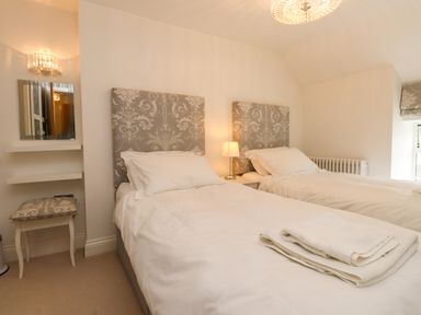A bedroom with twin beds and a mirror at Tan Y Goeden in Morfa Nefyn