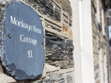 A stone wall with a slate plaque reading Moelwyn View Cottage 21 in Llan Ffestiniog