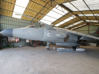 A military aircraft inside a hangar with visible cockpit and equipment around at Swan Lodge Castle Farm in Wedmore