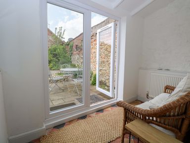 A sunroom with an armchair and a table at Springfield in Hempton near Fakenham