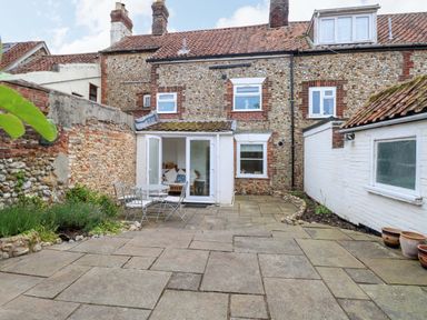 An outdoor area with a stone patio and seating at Springfield in Hempton near Fakenham