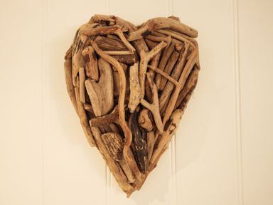A heart-shaped decoration made of various pieces of driftwood on a wall at Serendipity in Fowey