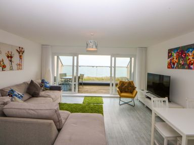 A living room with a sofa and television at Welymora in Pwllheli