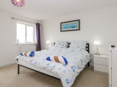 A bedroom with a bed and lamp at Welymora in Pwllheli