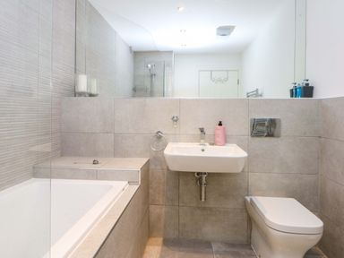 A bathroom with a bathtub, sink, and toilet at Welymora Pwllheli