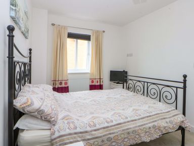 A bedroom with a bed and a tv at Welymora in Pwllheli