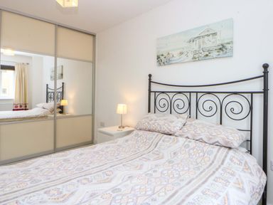 A bedroom with a bed and a bedside table at Welymora in Pwllheli