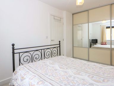 A bedroom with a bed and mirror at Welymora in Pwllheli