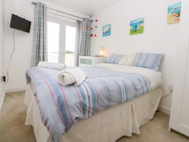A bedroom with a bed and television at Welymora in Pwllheli