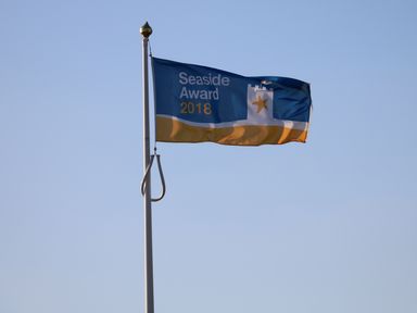 A flag with seaside award 2018 text on a flagpole against clear sky at Tilly's Retreat in Hunstanton