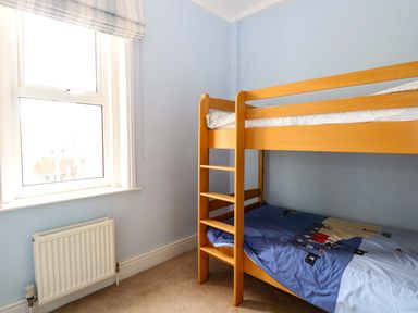 A bedroom with a bunk bed and window at Tilly's Retreat in Hunstanton