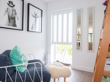 A living room with a sofa and artwork at Seaspell Beach House in Constantine Bay