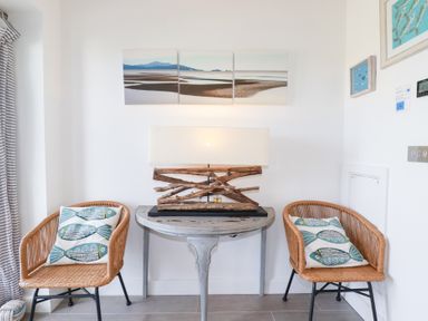 A snug with two chairs and a table at Seaspell Beach House in Constantine Bay