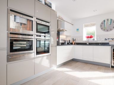 A kitchen with built-in ovens, sink, and cabinets at Seaspell Beach House in Constantine Bay