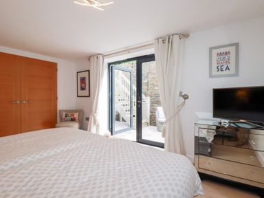 A bedroom with a bed and television at Seaspell Beach House in Constantine Bay