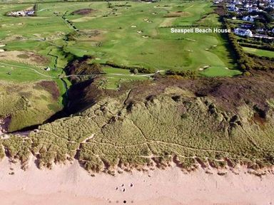 An aerial view of a beach and golf course at Seaspell Beach House in Constantine Bay