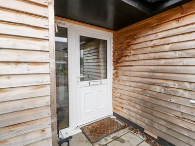 A white door with glass panels and a doormat outside at Vine Lodge in Kingsbury Episcopi near Martock