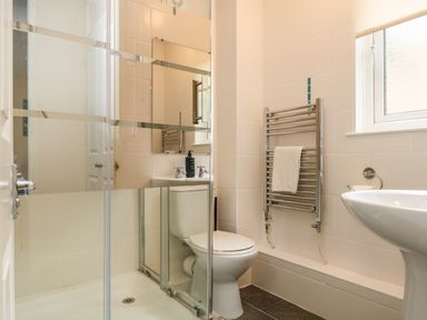 A bathroom with a shower enclosure a toilet a sink and a towel rack at Valley Lodge 48 Callington