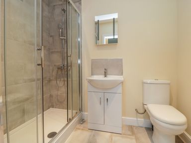 A bathroom with a shower enclosure a sink with cabinet and a toilet at Rose Lodge in Sheriff Hutton