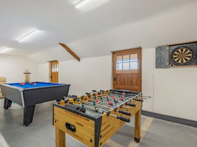 A game room with a foosball table pool table and dart board at Gwrtheyrn in Dyffryn Ardudwy
